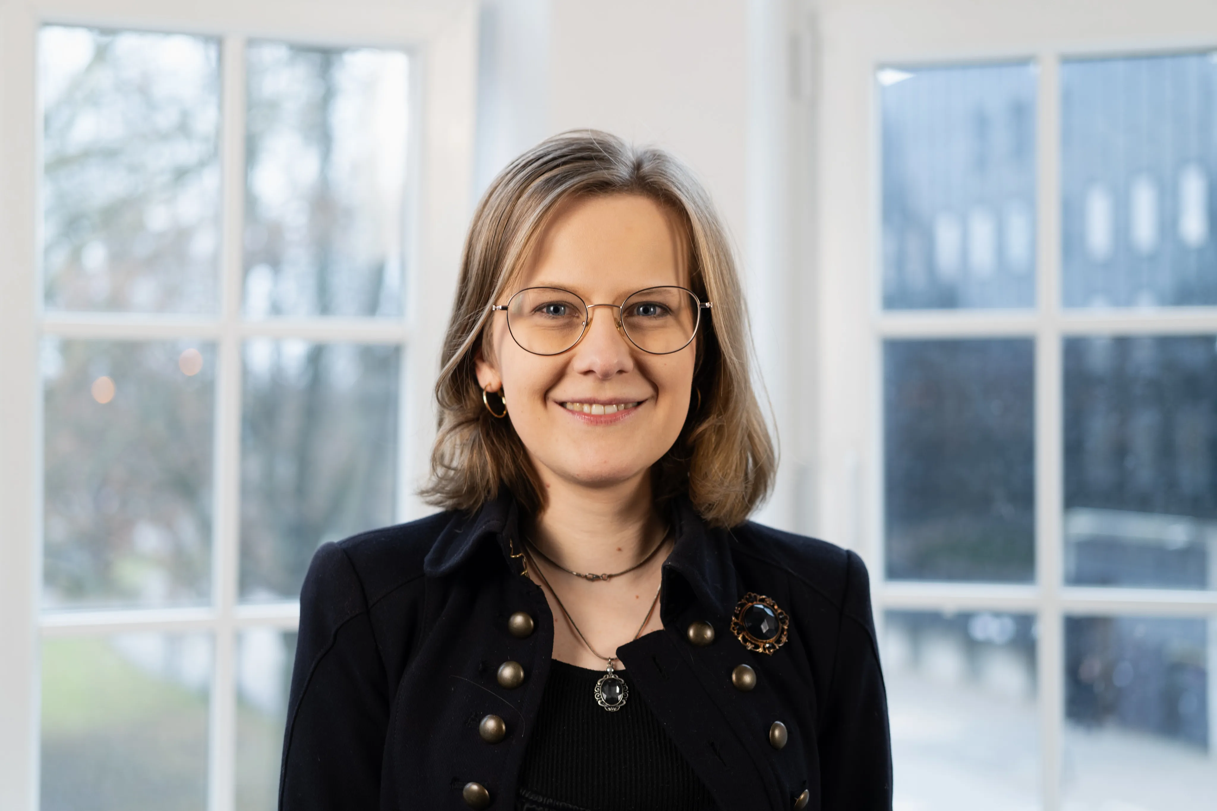 Gesa Krause lacht freundlich in die Kamera. Sie trägt dunkelblonde schulterlange Haare und ein schwarzes Oberteil.