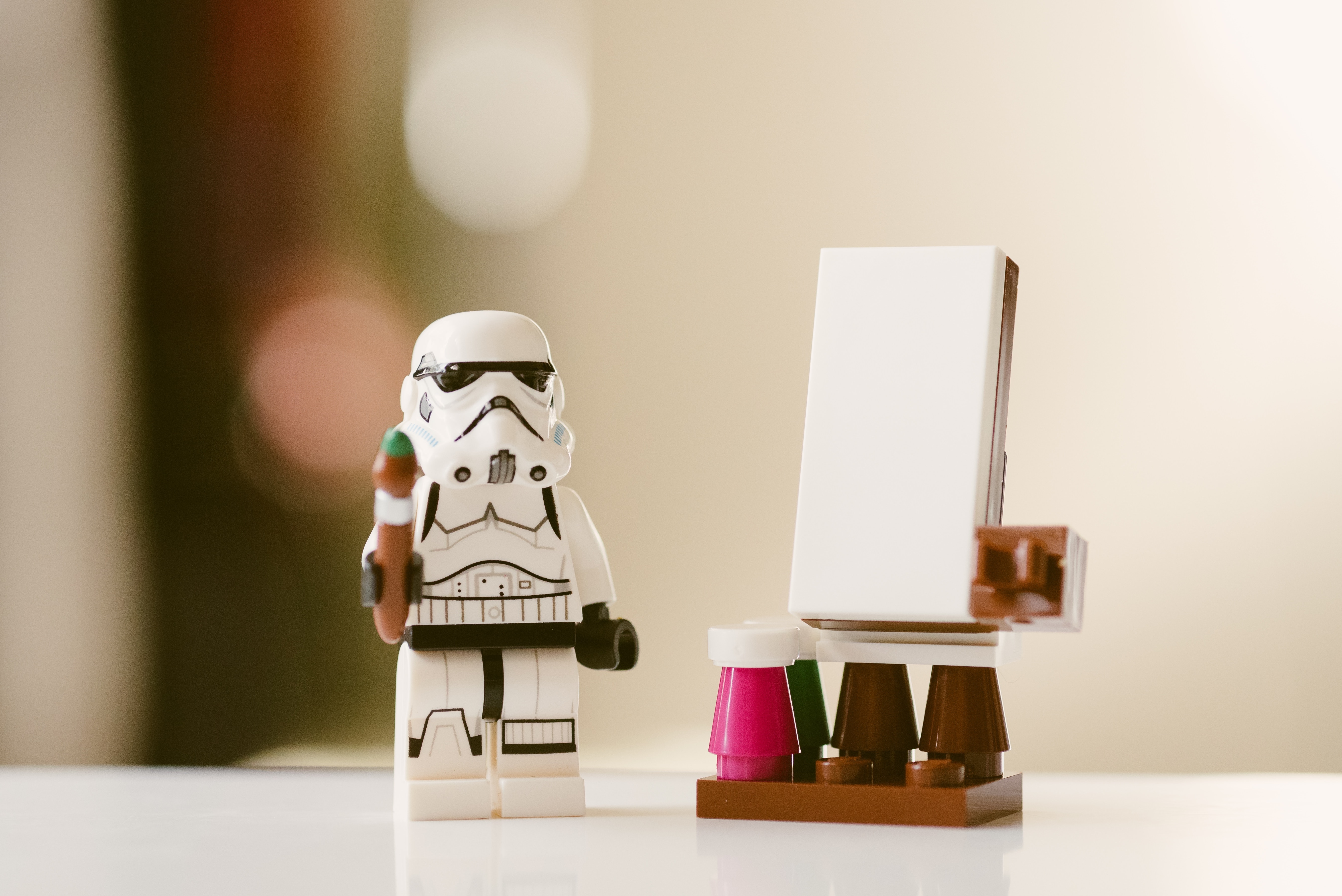 Die Lego-Figur eines Sturmtrupplers (bekannt aus dem Film Star Wars) steht neben einer kleinen Leinwand aus Lego und hält einen Lego-Künstlerpinsel in der Hand.